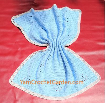 Light blue filet crochet cat blanket draped showing soft texture and finished size
