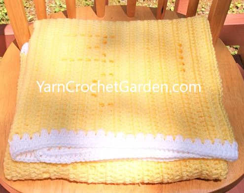Sun and cloud design detail on handmade You Are My Sunshine filet crochet blanket