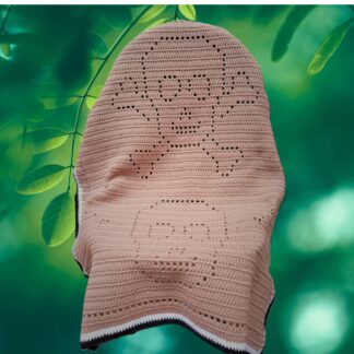 A handmade filet crochet blanket featuring detailed skull and skeleton motifs for Halloween decor.