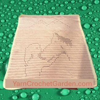 Finished filet crochet blanket featuring a girl patting a horse in a mountain landscape scene, handmade DIY craft project.