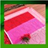 Filet crochet rose flower blanket pattern shown in red and pink yarn colors laid flat on a deck